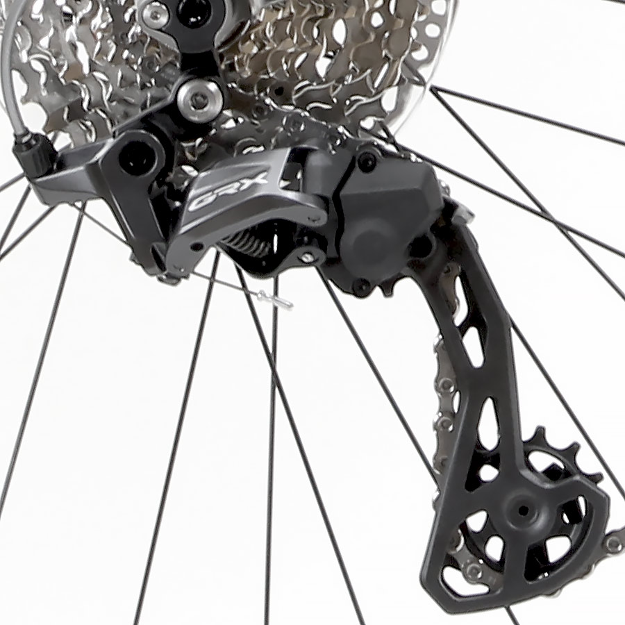 Side view of a titanium gravel bike with drop handlebars and wide tires