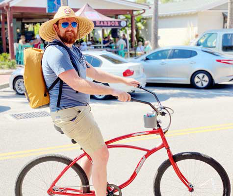 Cyclist enjoying a relaxed ride on a red beach cruiser during a rest day.