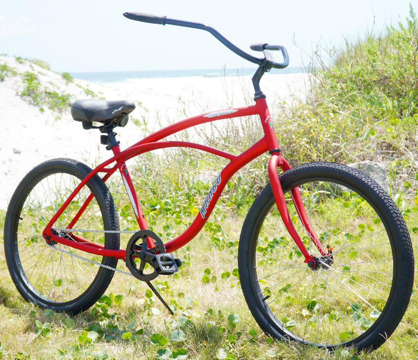 Affordable Mango Toucan beach cruiser bike in bright red, parked on the sand